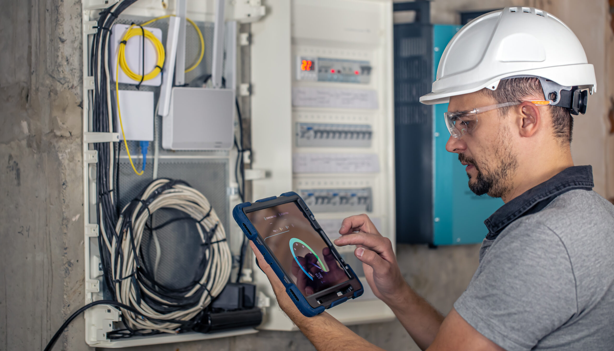 Man, an electrical technician working in a switchboard with fuses. Installation and connection of electrical equipment.